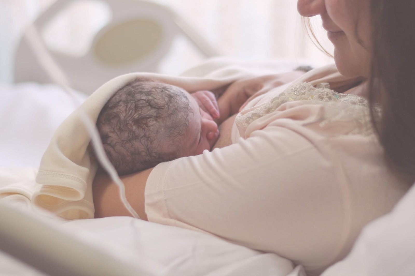 Moeder houdt haar pasgeboren baby huid-op-huid vast na de bevalling