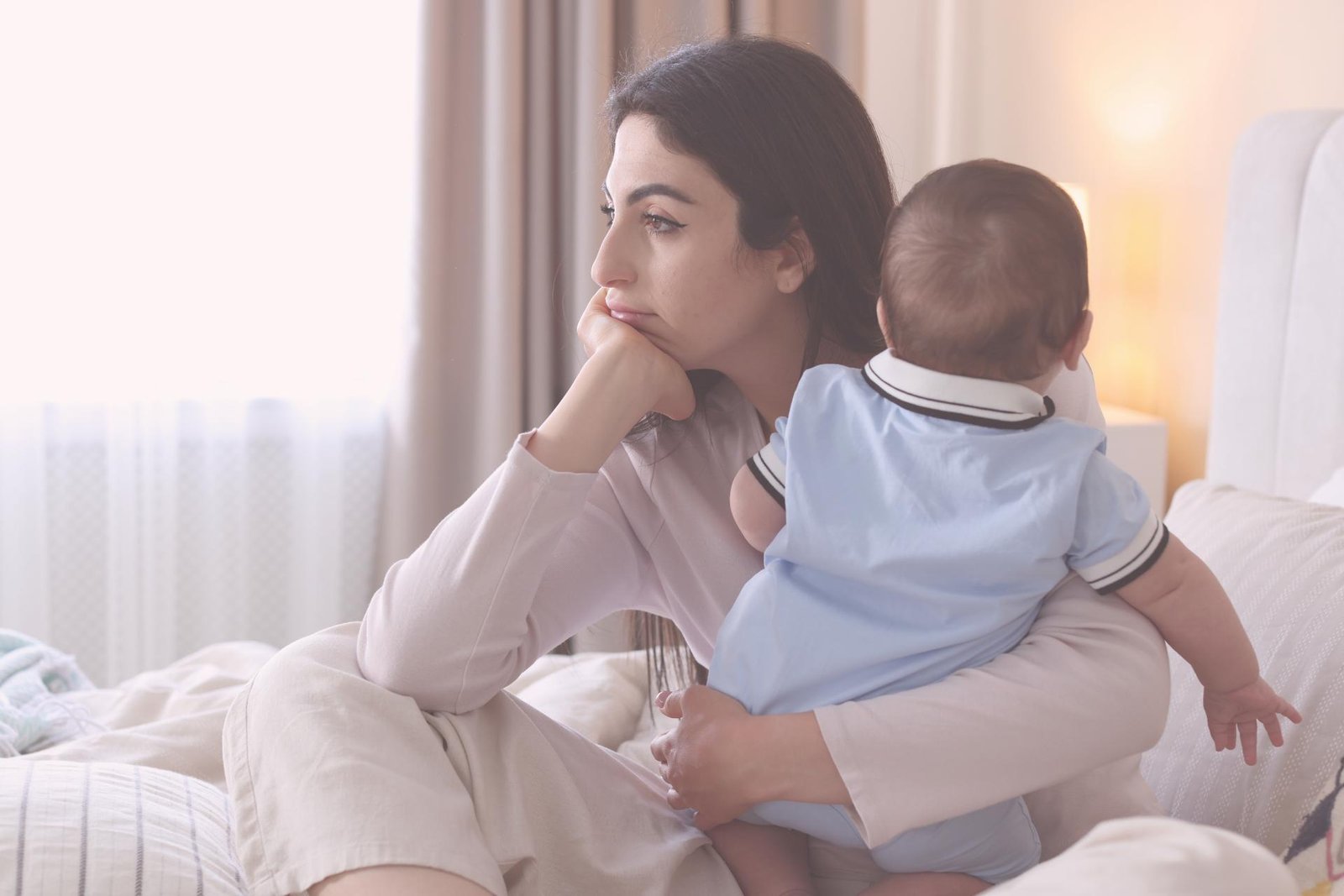 moeder ligt met baby op bed